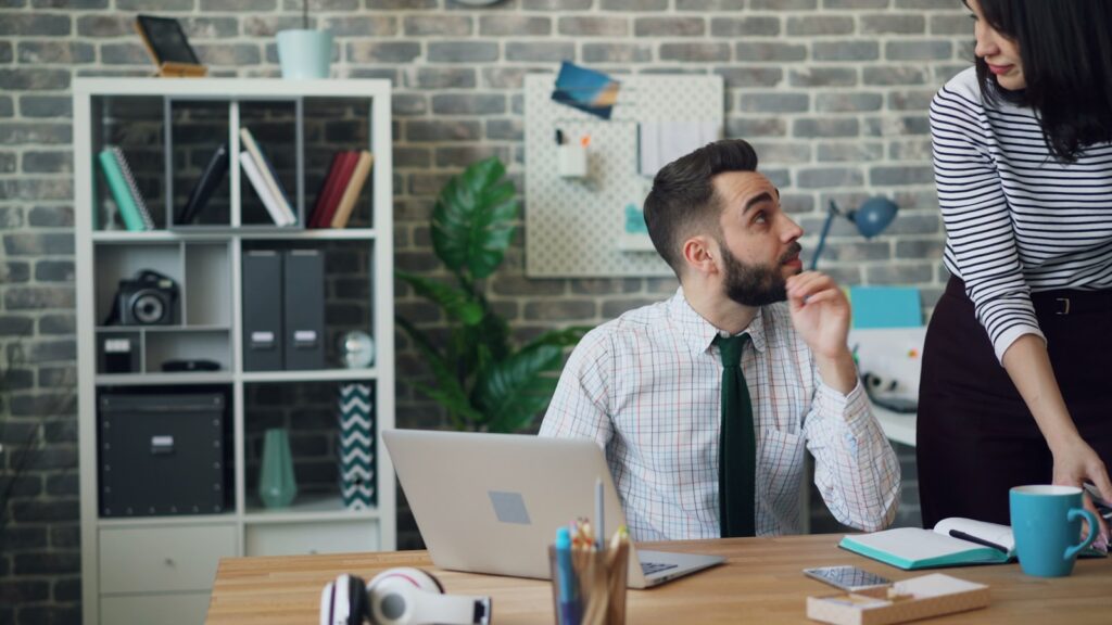 a man and a woman sitting at a desk in an office of B2B PPC Agency