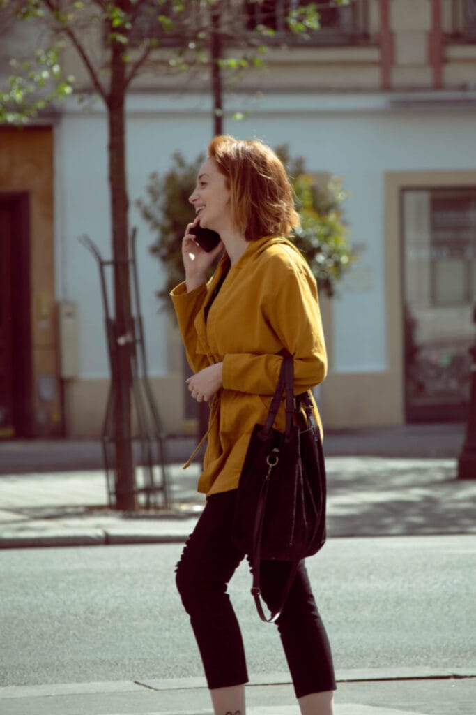 woman checking her phone on a European street while searching for a local business through Google Business Profile