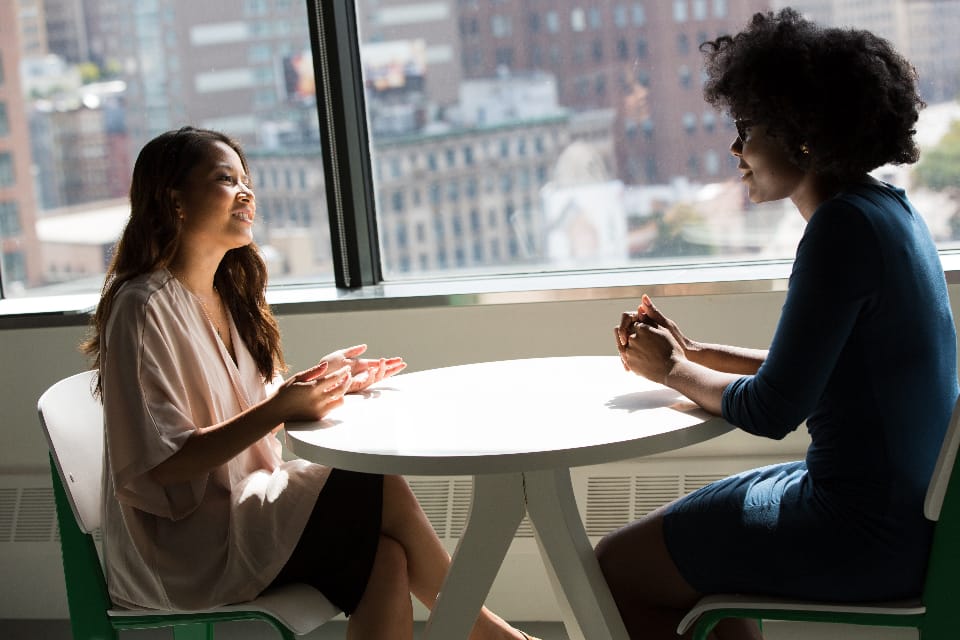 two professionals discussing SEO scope and pricing across a table during a client consultation
